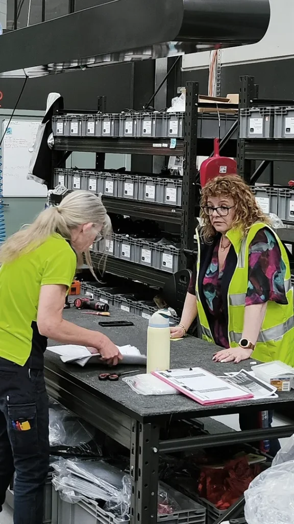 Production staff reviewing documents with warehouse as background
