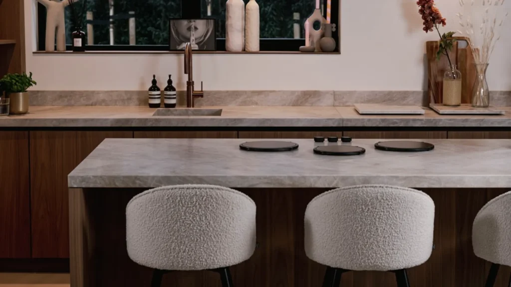 PITT Cooking Colo induction3 zone cooktop installed on a light colour marble bench top surrounded with warm wood tone cabinetry and beige bar stools